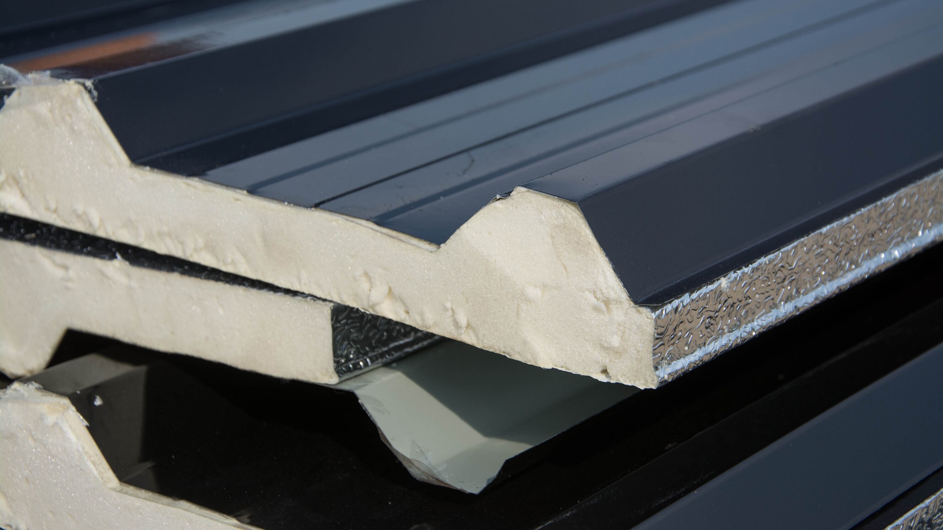 black metal sheet roof with insulation attached under metal sheet.