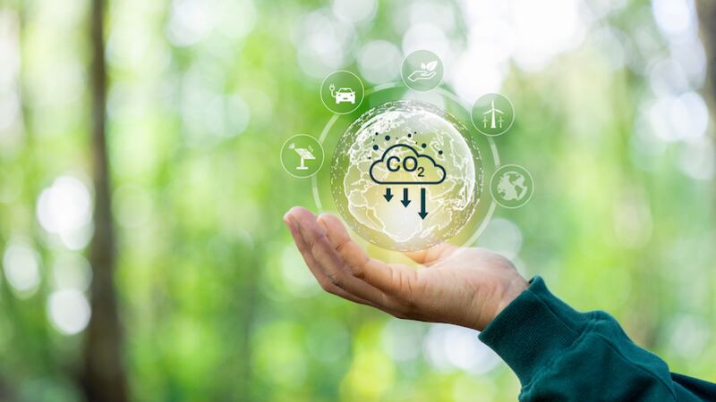 a hand holding an image suggesting reduction in carbon dioxide emissions