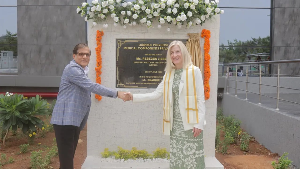 a man and a woman shaking hands in front of a plaque