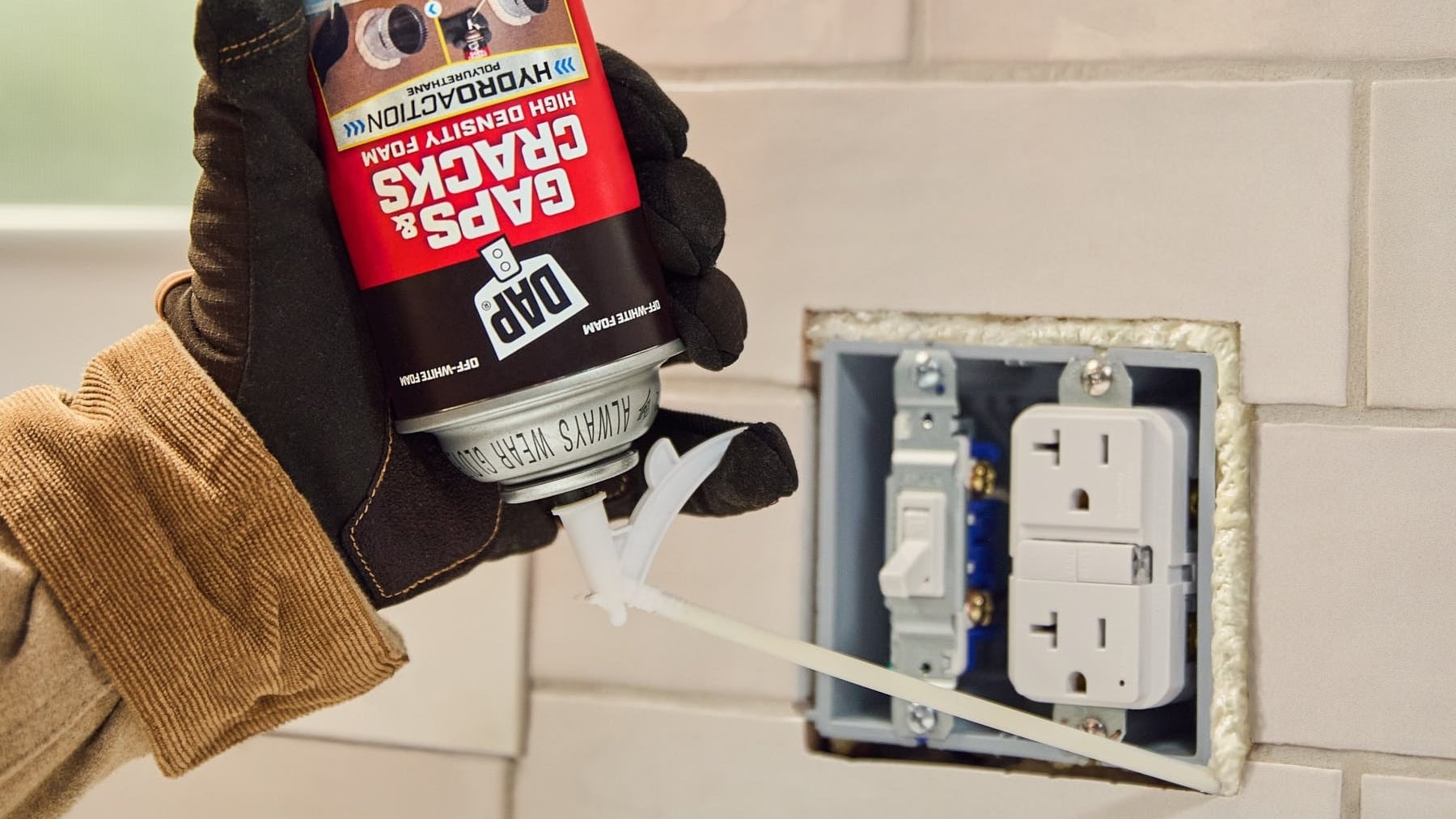 a spray foam sealant being applied around an electrical outlet