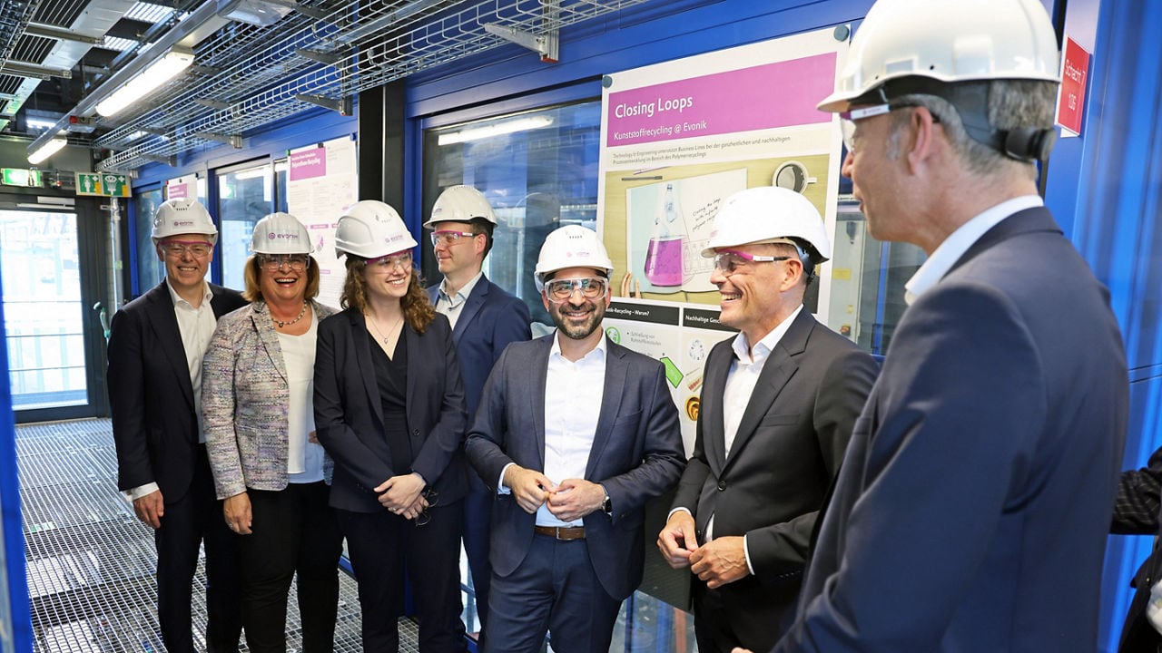 a group of people wearing hard hats in front of a display board